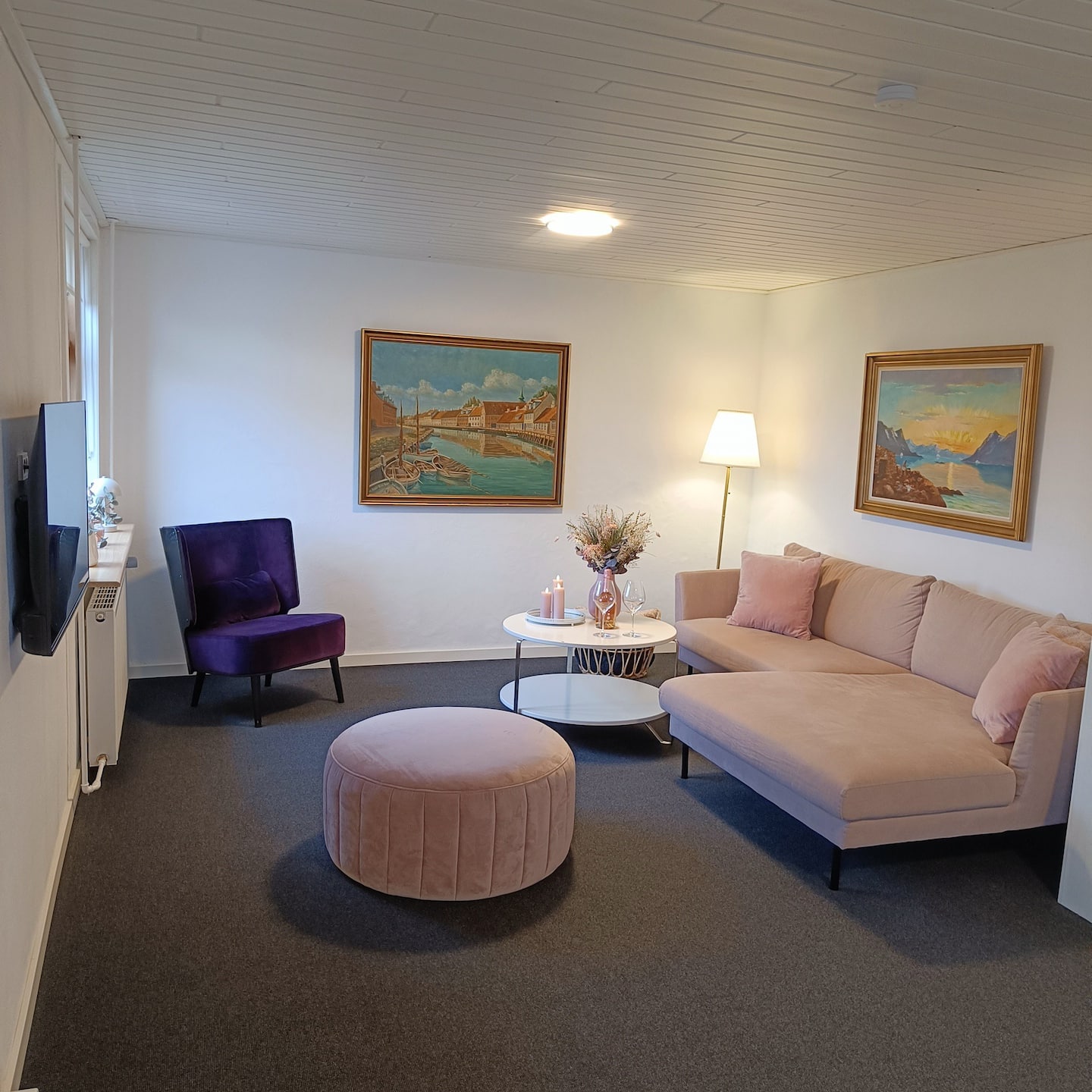 Stue med linnedsofa og levende lys